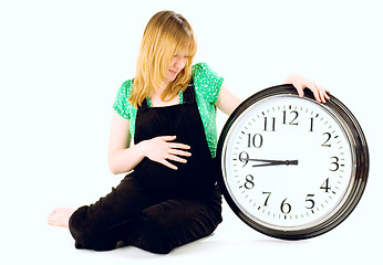 Image showing pregnant woman with a clock