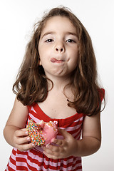 Image showing Girl eating doughnut licking lips