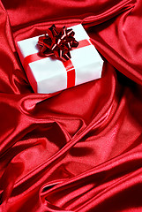 Image showing gift box on red satin background