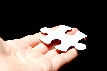 Image showing Hand holding a puzzle piece