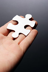 Image showing Hand holding a puzzle piece