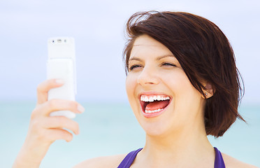 Image showing happy woman with phone on the beach