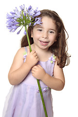 Image showing Little girl holding large african lily - agapanthus