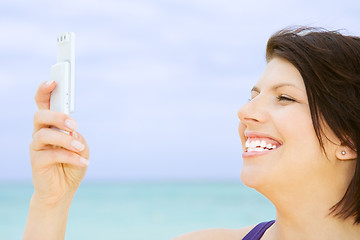 Image showing happy woman with phone on the beach