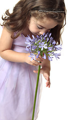 Image showing Girl smelling a beutiful flower