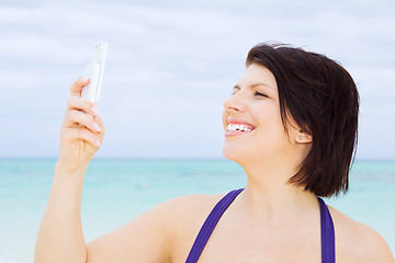 Image showing happy woman with phone on the beach