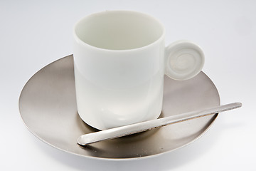 Image showing White coffe cup with metal saucer on white.