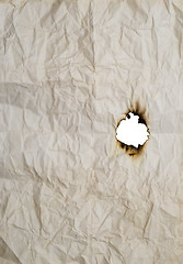 Image showing burnt hole in wrinkled paper