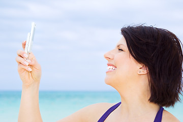 Image showing happy woman with phone on the beach