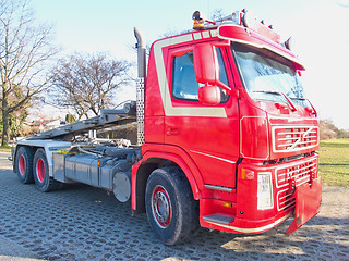 Image showing Front side view of red skip truck with hydraulic arm