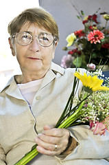 Image showing Elderly woman with flowers