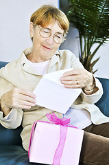 Image showing Old woman opening present