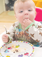 Image showing Cute baby toddler on his first birthday eating cake