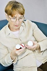 Image showing Elderly woman reading pill bottles