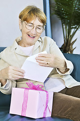 Image showing Old woman opening present