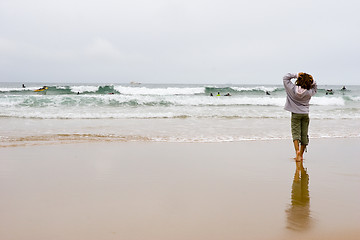 Image showing girl looking at surfers