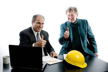 Image showing two business partners at desk shaking hands