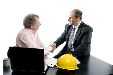 Image showing two business partners at desk shaking hands