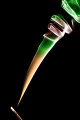 Image showing Stick with a color smoke. Isolated on black