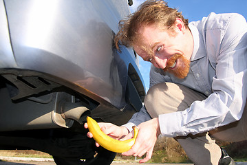 Image showing Man putting banana into car exhaust