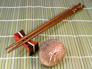 Image showing Chopsticks and mushroom over a bamboo background