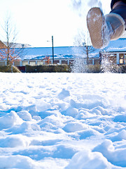 Image showing Boot kicking up snow in a field