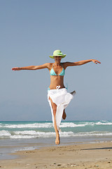 Image showing Beautiful young woman jumping on a beach in Greece