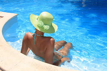 Image showing Young woman enjoying a swimming pool