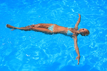 Image showing Young woman enjoying a swimming pool