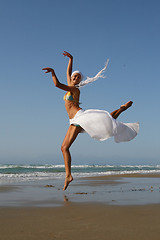 Image showing Beautiful young woman jumping on a beach in Greece