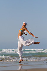 Image showing Beautiful young woman jumping on a beach in Greece