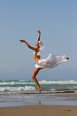 Image showing Beautiful young woman jumping on a beach in Greece