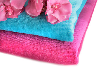 Image showing Pink and blue towels with flowers on a table