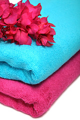 Image showing Pink and blue towels with flowers on a table