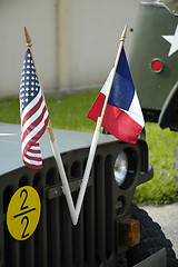 Image showing US and french flags front of an old jeep