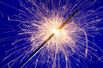 Image showing sparkler against blue background.