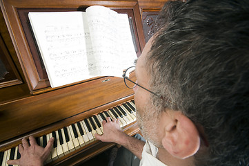 Image showing senior middle age man playing piano