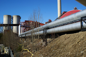 Image showing industrial pipelines on pipe-bridge against blue sky