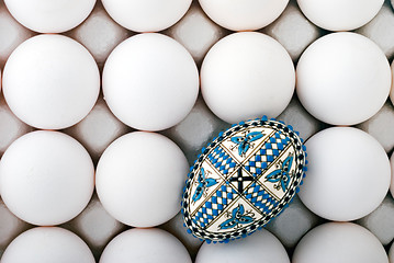 Image showing handmade romanian decorated easter egg on white eggs cardboard