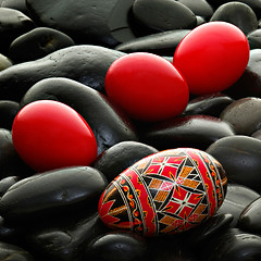 Image showing handmade romanian decorated easter egg on black gravel bed