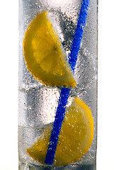 Image showing Glass of drink with ice cubes, straw and lemon slice