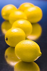 Image showing lemons on  blue reflective background