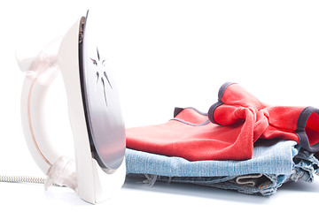 Image showing electric iron and pile of clothes