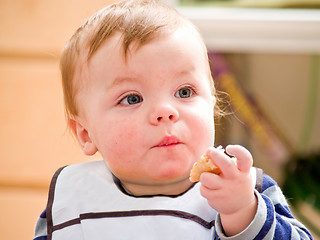 Image showing Cute little baby boy eating bread