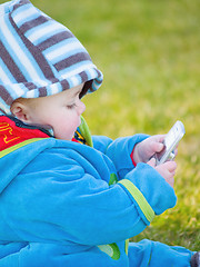 Image showing Colourful baby boy playing with cell phone