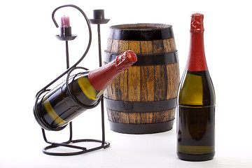 Image showing Two Bottles,wine barrel, support and candle