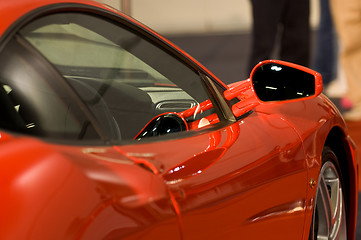 Image showing Right side mirror of shiny red car