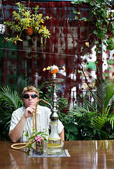 Image showing Man smoking a hookah.