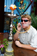 Image showing Man smoking a hookah.