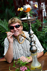 Image showing Man smoking a hookah.